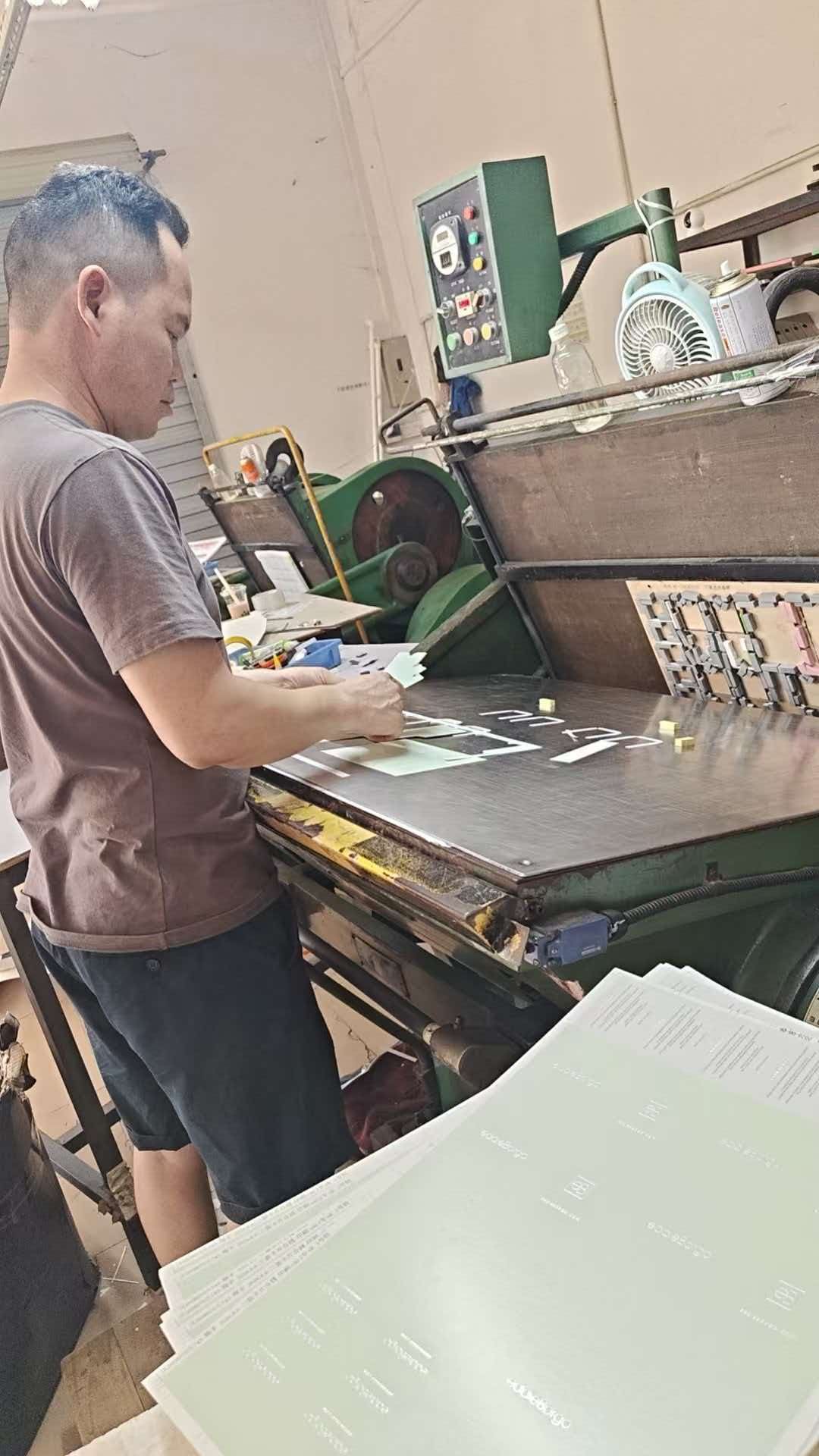 Operator working at the material cutting table in the Yishu Bag factory